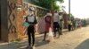 Les gens font la queue pour une distribution alimentaire en pleine pandémie de coronavirus, à Chitungwizaon, Zimbabwe, le 5 mai 2020.