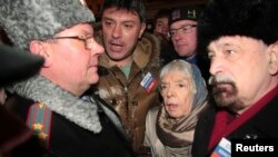 FILE - A police officer talks to leading opposition figure Boris Nemtsov (2nd L) and human rights activist and Moscow Helsinki group chairperson Lyudmila Alekseyeva (2nd R) during a rally in central Moscow January 31, 2010.