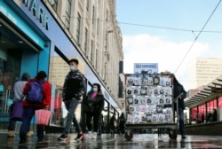 A man sells face masks, following the outbreak of the coronavirus disease, on a street in Manchester, Britain, Oct. 7, 2020.