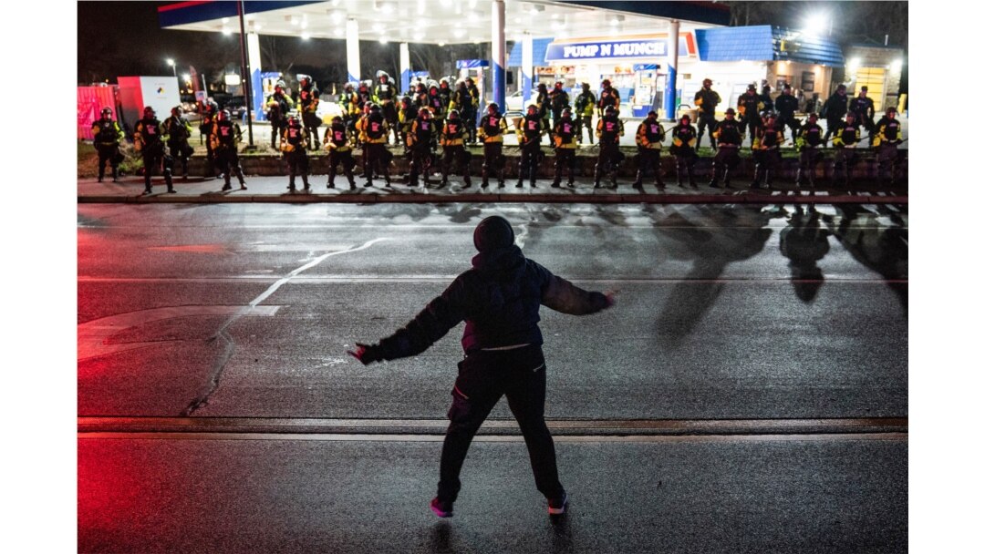 A demonstrator heckles authorities who advanced into a gas station after issuing orders for crowds to disperse during a protest against the police shooting of Daunte Wright, April 12, 2021, in Brooklyn Center, Minnesota.