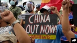 在海牙国际仲裁庭就菲律宾与中国海洋权利纠纷作出裁决五周年之际，抗议者举着标语在中国驻菲律宾马卡蒂领事馆外集会。(2021年7月12日)