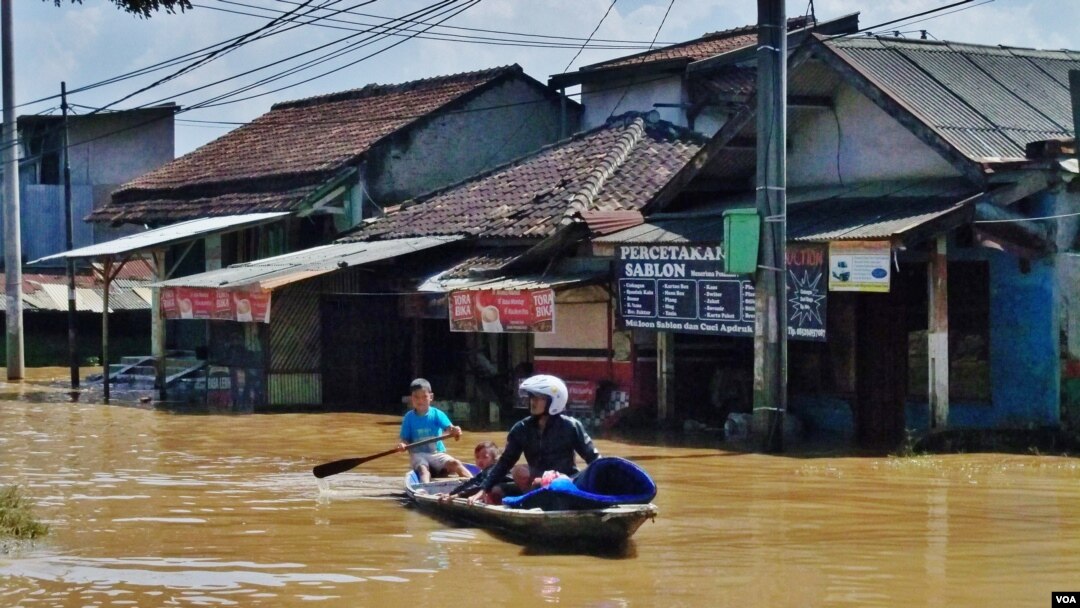 Warga memanfaatkan perahu sebagai alat transportasi saat banjir melanda Kabupaten Bandung, Jawa Barat (VOA/Teja Wulan).