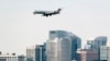 Con edificios de gran altura vistos en Rosslyn, Virginia, los vuelos de pasajeros se preparan para aterrizar en el cercano Aeropuerto Nacional Reagan de Washington en Arlington, Virginia, al otro lado del río Potomac desde Washington, el miércoles 19 de enero de 2022.