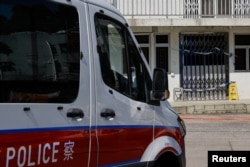 A police van is seen outside a village house where part of Abby Choi's body was found in Hong Kong