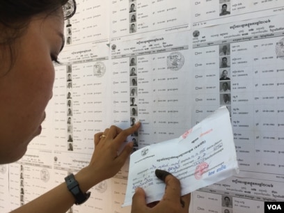 រូបឯកសារ៖ កញ្ញាជិន ស្រីធុច អាយុ១៨ឆ្នាំ សកម្មជនរបស់គណបក្សសង្គ្រោះជាតិ កំពុងរកឈ្មោះ និងលេខរៀងរបស់អ្នកបោះឆ្នោតនៅក្នុងឃុំដំដែកស្រុកសូត្រនិគមនៅការិយាល័យបោះឆ្នោតក្នុងវិទ្យាល័យដំដែក ខេត្តសៀមរាប។