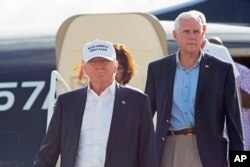 Republican presidential candidate Donald Trump, followed by his running mate, Indiana Gov. Mike Pence, emerges from his plane as he arrives to tour the flood damaged city of Baton Rouge, La., Aug. 19, 2016.