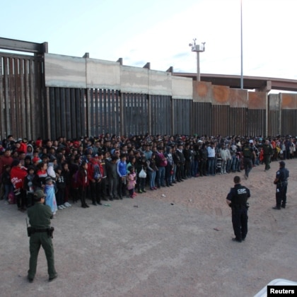 A photograph of U.S. Border Patrol agents keeping watch on a large group of migrants whoin El Paso, Texas, May 29, 2019. (Reuters)