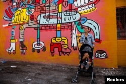 A woman stands by a mural titled 'Outside' in Mejicanos, El Salvador, July 11, 2024.