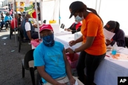 FILE - A patient receives a Johnson &amp; Johnson vaccine at a pop-up vaccination center, at the Bare taxi rank in Soweto, South Africa, Aug. 20, 2021.