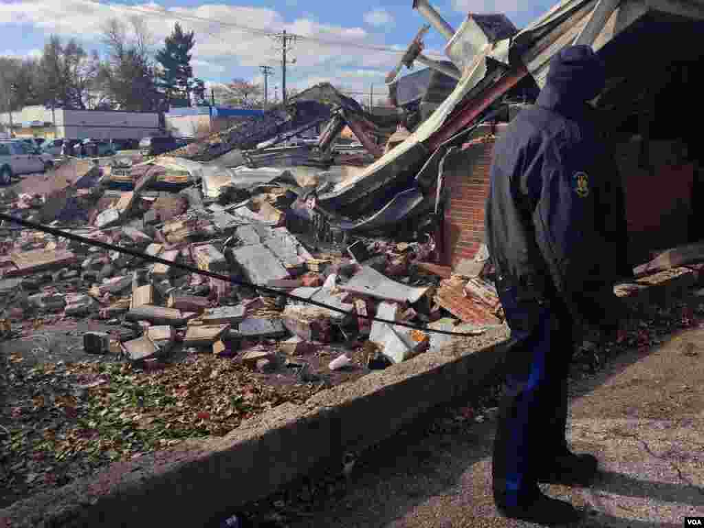 An officer surveys the ruins of a beauty supply store destroyed after a grand jury's decision was announced in Ferguson, Mo.