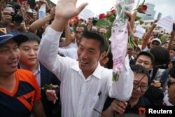 Thanathorn Juangroongruangkit, leader of the Future Forward Party, greets his supporters as he arrives at a police station to hear a sedition complaint filed by the army in Bangkok, April 6, 2019.