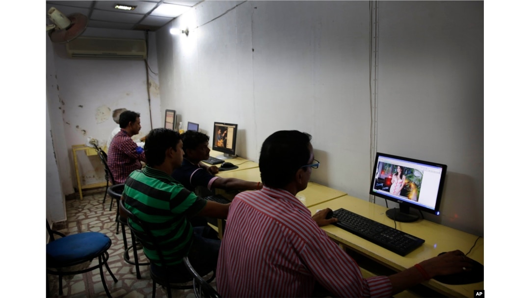 FILE - Indian youth use the internet at a cyber cafe in Allahabad, India.