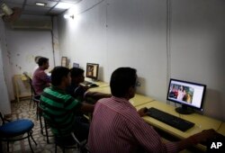 FILE - Indian youth use the internet at a cyber cafe in Allahabad, India.