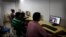 FILE - Indian youth use the internet at a cyber cafe in Allahabad, India. The hotline is a simple online form which the public, police, internet companies and victims can access in either Hindi or English.