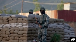 Border Security Force soldiers stand guard near the site of a shootout on the outskirts of Srinagar, Indian controlled Kashmir, May 20, 2020.