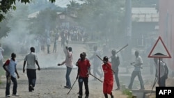 FILE - Members of the Imbonerakure, armed with sticks, chase protesters opposed to the Burundian president's third term in the Kinama neighborhood of Bujumbura. Taken 5.25.2015