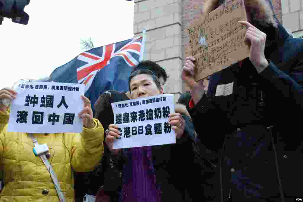 「驅蝗行動」遊行人士高舉標語指大陸遊客來香港搶奶粉，要求他們返回大陸