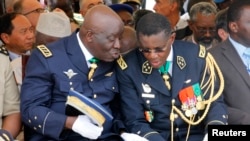 L’ancien chef d'état-major de l'armée ivoirienne, Philippe Mangou, à gauche, échange avec le commandant de la gendarmerie, le général Edward Tiape, à droite, d’une cérémonie au Plateau Abijan, 12 juillet 2011.