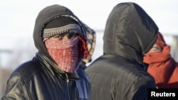 FILE - Refugees and migrants gather near a checkpoint on the Russian-Norwegian border in Murmansk region, Russia, Oct. 30, 2015.