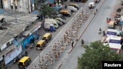 Polisi India melakukan pawai di jalanan Dharavi, daerah kumuh terbesar di Asia, saat diberlakukannya perpanjangan masa karantina di kawasan Maharashtra, Mumbai, India, 11 April 2020. (Foto: dok). Lebih dari 100 orang ditangkap karena tindak kejahatan di kawasan ini.