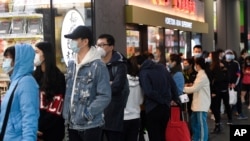 FILE - People line up to enter a supermarket hours before a citywide curfew is introduced in Melbourne, Aug. 2, 2020.