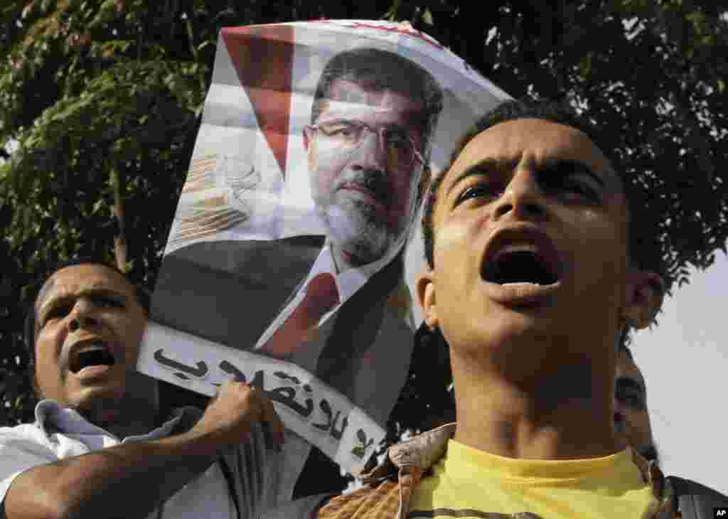 A supporter of Egypt's ousted President Mohammed Morsi raises his poster during a protest in front of the supreme constitutional court in Cairo, Egypt, Nov. 4, 2013. The Arabic text reads, "no to the coup." 