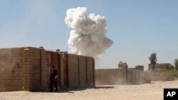Asap mengepul pasca serangan bom bunuh diri di Lashkar Gah, Afghanistan hari Senin (10/10).