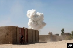 Smoke rises after a suicide attack in Lashkar Gah the capital of southern Helmand province of Afghanistan, Oct. 10, 2016.