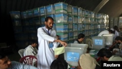 Afghan election workers count ballot papers for an audit of the presidential run-off in Kabul, Afghanistan, Aug. 6, 2014.