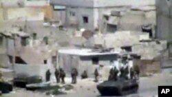 Image taken from amateur video purports to show armored vehicles and troops taking up positions in Latakia on August 15, 2011. (The content and location of this image cannot be independently verified.)