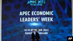 Thai officers walk in front of a sign of Asia-Pacific Economic Cooperation (APEC) in Bangkok, Nov. 14, 2022.