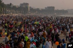Orang-orang memadati pantai Juhu di pantai Laut Arab di Mumbai, India, Minggu, 13 November 2022. Populasi dunia diproyeksikan mencapai sekitar 8 miliar orang pada Selasa, 15 November, menurut proyeksi PBB. (AP/Rafiq Maqbool)