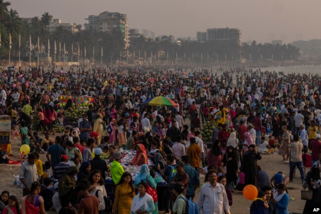 Orang-orang memadati pantai Juhu di pantai Laut Arab di Mumbai, India, Minggu, 13 November 2022. Populasi dunia diproyeksikan mencapai sekitar 8 miliar orang pada Selasa, 15 November, menurut proyeksi PBB. (AP/Rafiq Maqbool)