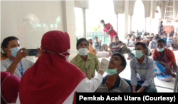 Petugas medis melakukan pemeriksaan terhadap ratusan orang etnis Rohingya yang terdampar di pesisir pantai Meunasah Lhok, Kecamatan Muara Batu, Kabupaten Aceh Utara, Provinsi Aceh, Selasa 15 November 2022. (Courtesy: Pemkab Aceh Utara)