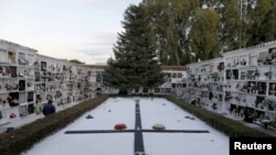 FILE - A man walks past a big tombstone commemorating those who died during the Spanish Civil War, at a cemetery ahead of All Saints Day, in Ronda, Spain, Oct. 28, 2020. 