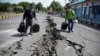 Warga berjalan di jalan yang rusak akibat gempa besar di Pelabuhan Kayangan, Lombok, 20 Agustus 2018. (Foto: dok). 