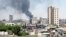 Smoke rises from buildings hit by shelling in Homs, Syria