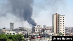 Smoke rises from buildings hit by shelling in Homs, Syria