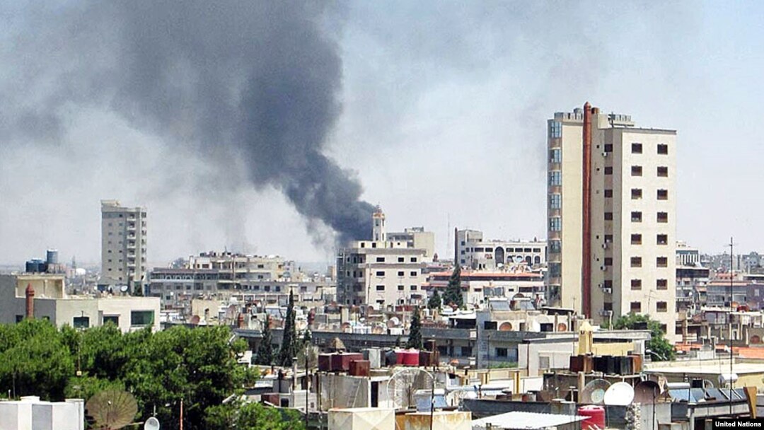 Smoke rises from buildings hit by shelling in Homs, Syria