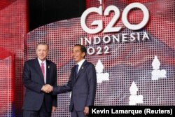 Presiden Turki Recep Tayyip Erdogan menyapa Presiden Joko Widodo saat tiba di KTT para pemimpin G20 di Nusa Dua, Bali, 15 November 2022. (Foto: REUTERS/Kevin Lamarque)