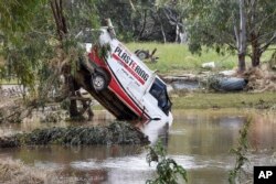 One of the many vehicles swept away during a flash flood, sits embedded in a tree in the town of Eugowra, Central West New South Wales, Australia, Nov. 15, 2022.