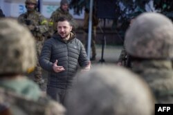 This handout photograph taken and released by Ukrainian Presidential press service on Nov. 14, 2022, shows Ukrainian President Volodymyr Zelensky speaking to servicemen during his visit to the newly liberated city of Kherson, following the retreat of Russ