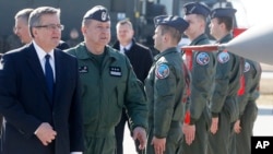 Poland’s President Bronislaw Komorowski,left, and the commander of Poland’s Air Force, Gen. Lech Majewski visit Lask airbase, central Poland, March 11, 2014.