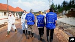 European Union Assessment Experts who are assessing damage caused by toxic red mud flood walk down main street of Kolontar village,164 kms southwest of Budapest, Hungary, 13 Oct. 2010