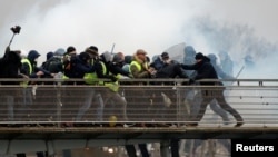Former French boxing champion, Christophe Dettinger (R), is seen during clashes with French Gendarmes at a demonstration by the "yellow vests" on the passerelle Leopold-Sedar-Senghor bridge in Paris, France, January 5, 2019. 