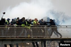 Campeão de boxe, Christophe Dettinger (à direita), durante um confronto com a polícia francesa numa manifestação dos coletes amarelos. Paris, França, 5 janeiro, 2019.