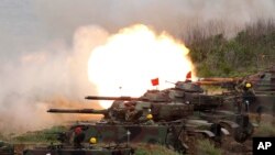 FILE- A line of U.S. tanks fire at targets during exercises on the outlying Penghu Island, Taiwan, May 25, 2017. A statement of congressional support for the defense of Taiwan was included in a compromise version of the fiscal 2022 National Defense Authorization Act.