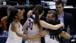 ຫົວໜ້າທີມຄູຝຶກ ທ່ານ Geno Auriemma ກອດນາງ Morgan Tuck (3) ນາງ Moriah Jefferson (4) ແລະນາງ Breanna Stewart (30) ຫລັງຈາກໄດ້ຮັບໄຊຊະນະ.