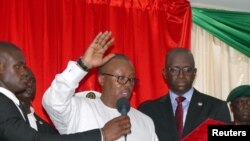 FILE - Guinea-Bissau's newly elected president, Umaro Cissoko Embalo, raises his arm during his swearing-in ceremony in Bissau, Guinea Bissau Feb. 27, 2020.