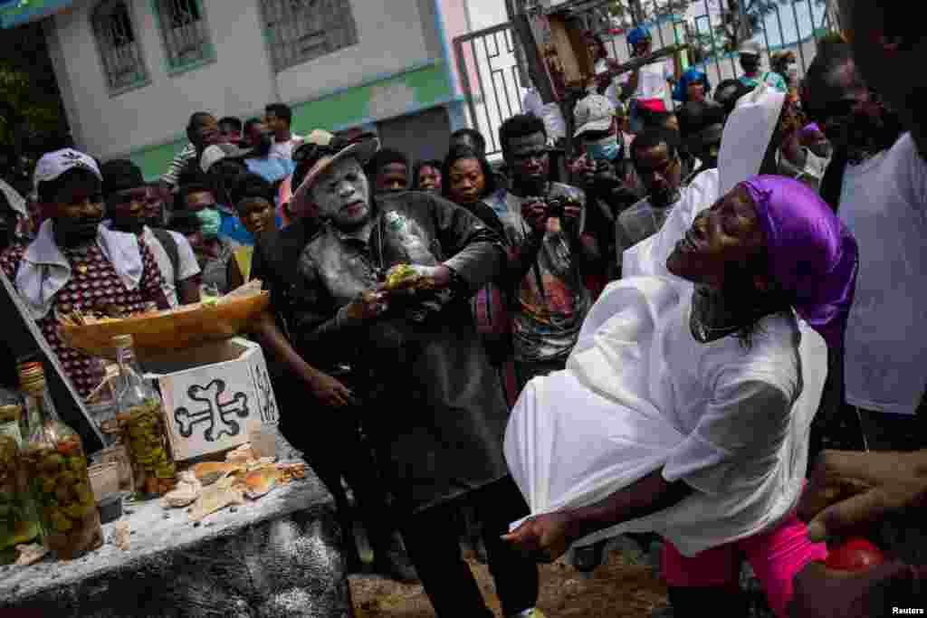 Voodoo followers, called Pitit Fey, attend a ceremony during the Day of the Dead celebrations at the Meyotte cemetery in Kay Gouye, in Port-au-Prince, Haiti, Nov. 1, 2021.